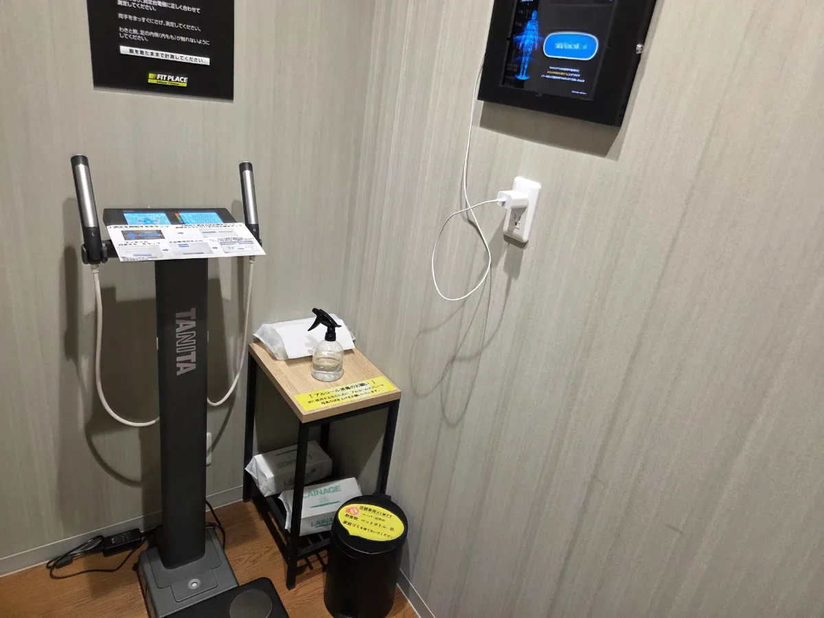 FIT PLACE24の店舗に設置されたTANITA製の体組成計と、測定結果を表示するタブレット